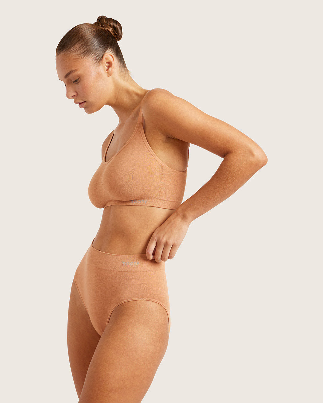 Woman wearing a beige two-piece set on a light background