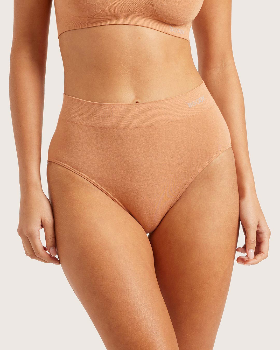 Beige high-waisted underwear on a plain background