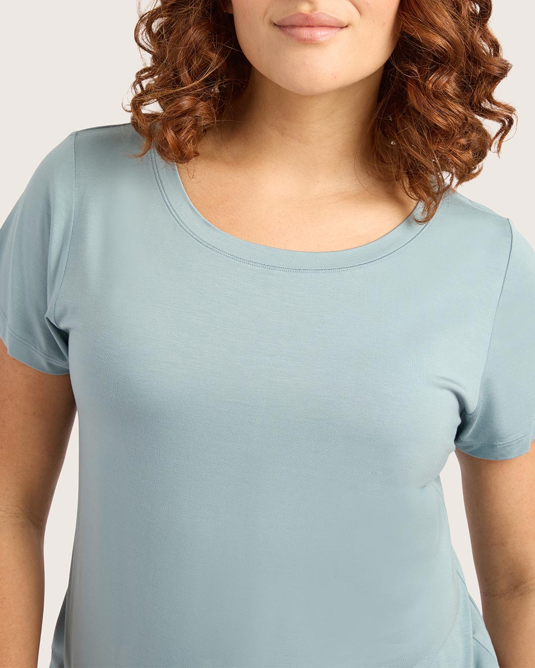 Person wearing a light blue t-shirt against a plain background