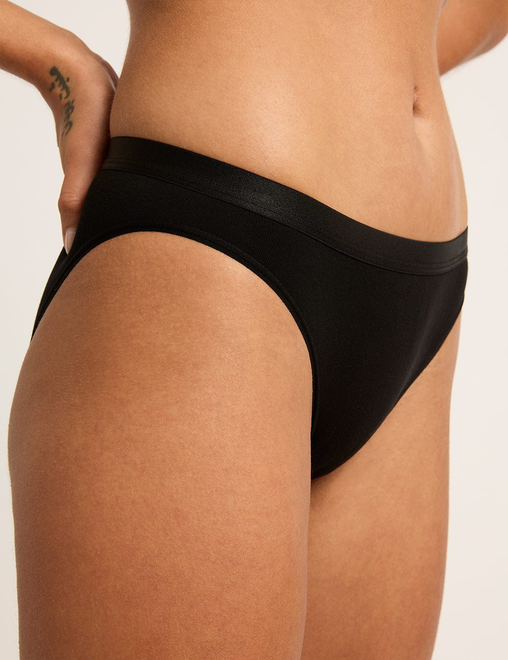 Black panty worn by a person on a plain background