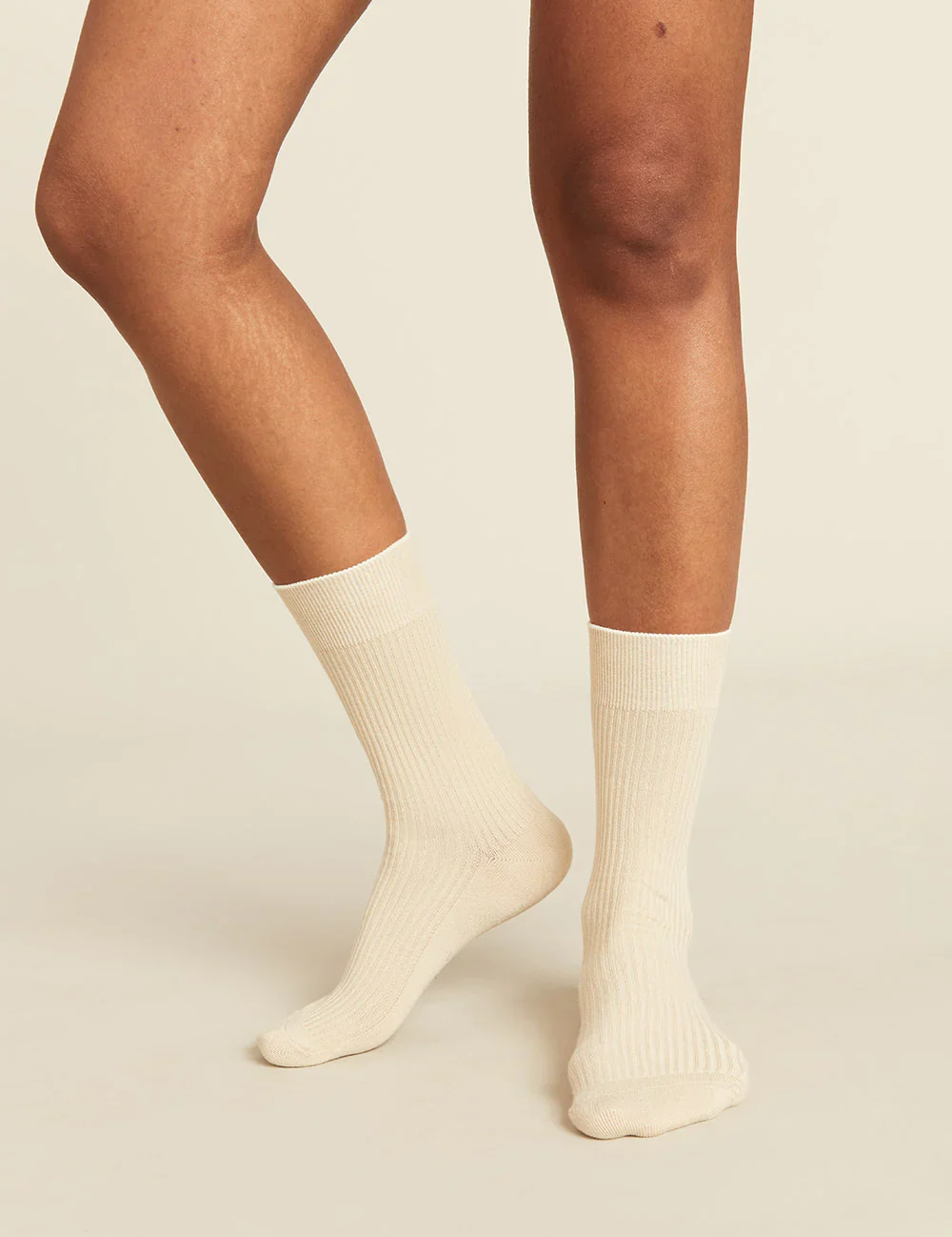 Beige socks worn by a person on a beige background