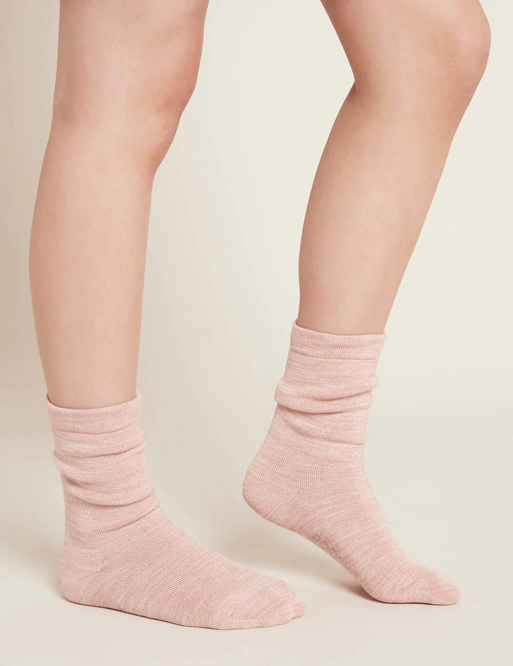Pink socks worn by a person on a plain background