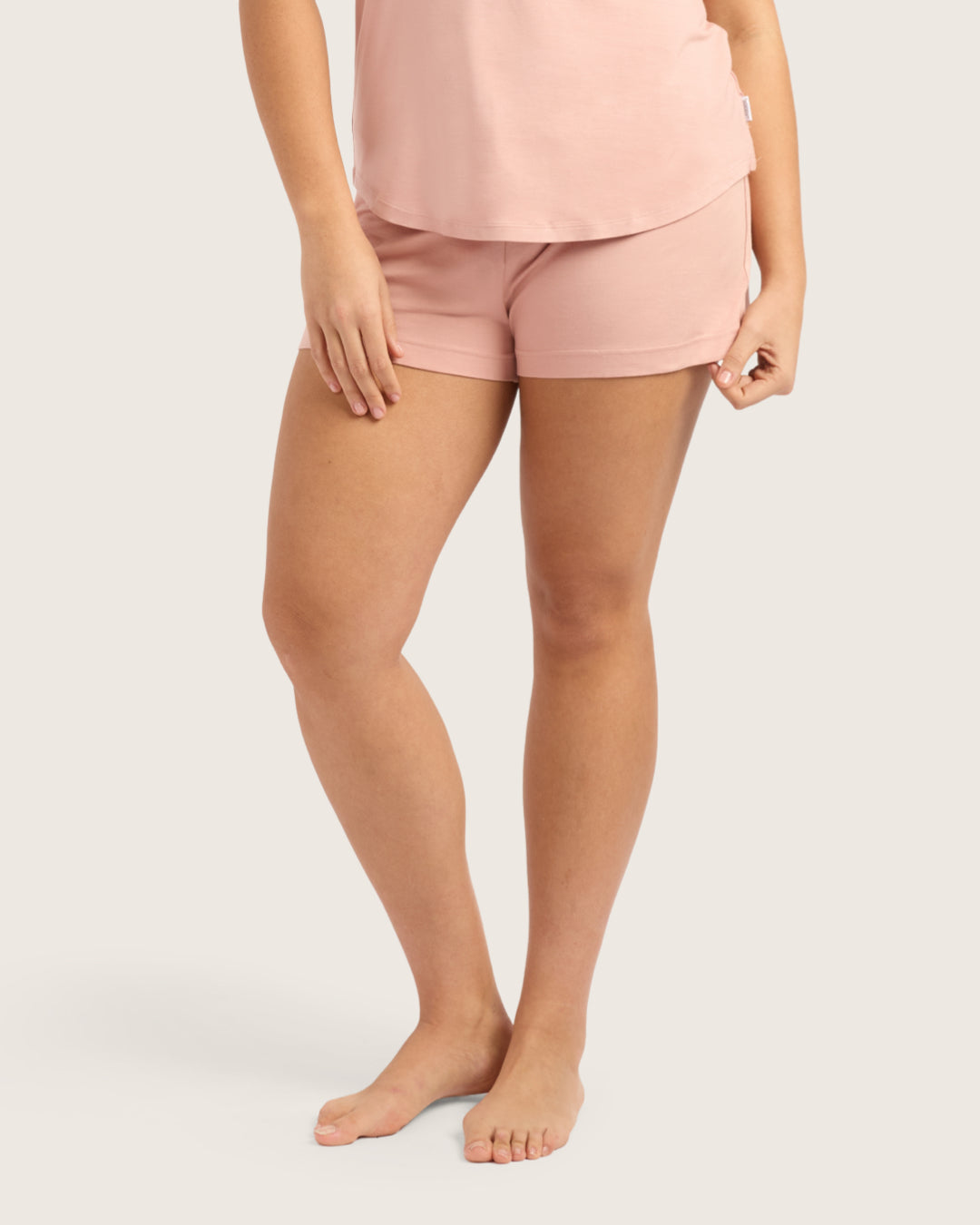 Person wearing pink shorts on a plain background