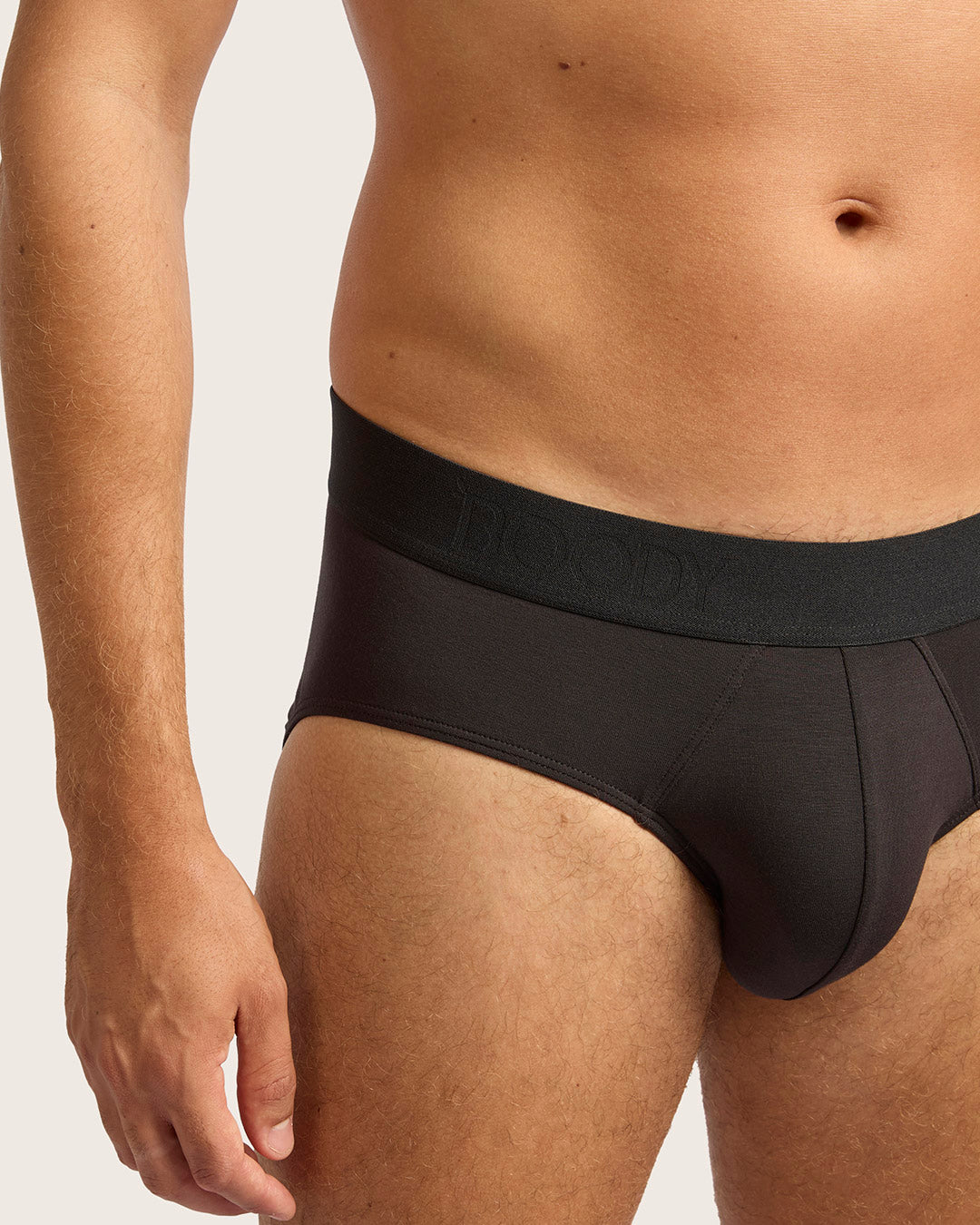 Black underwear worn by a person on a light gray background