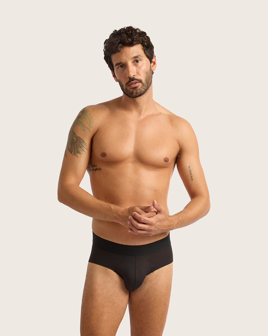 Man wearing black underwear against a plain background
