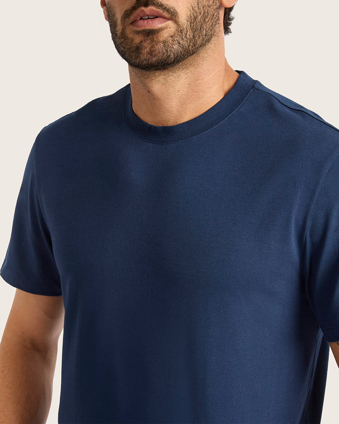 Man wearing a navy blue t-shirt against a plain background