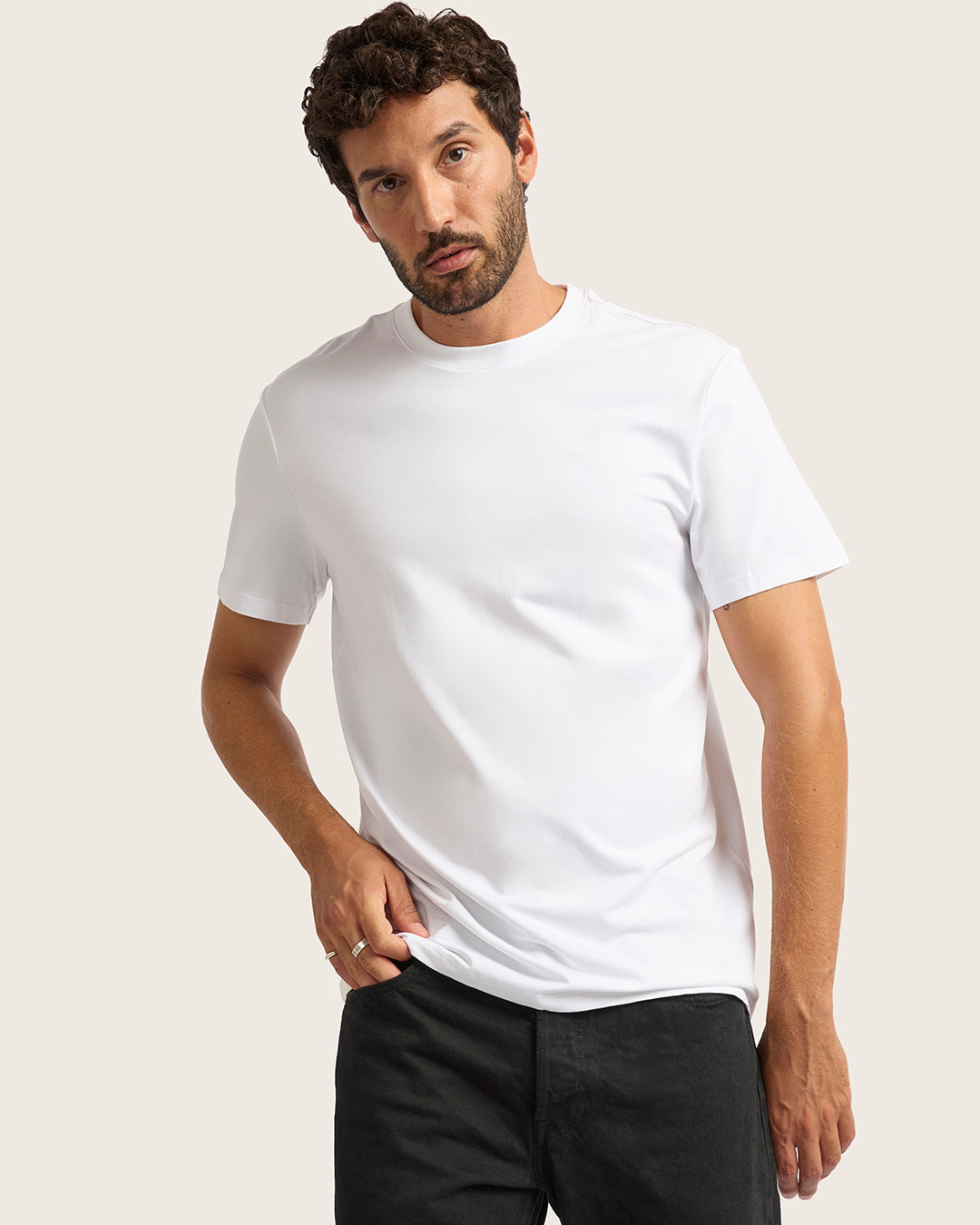 Man wearing a plain white t-shirt against a light background