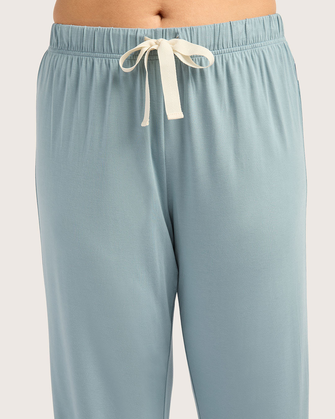 Light blue pants with a white drawstring on a light gray background