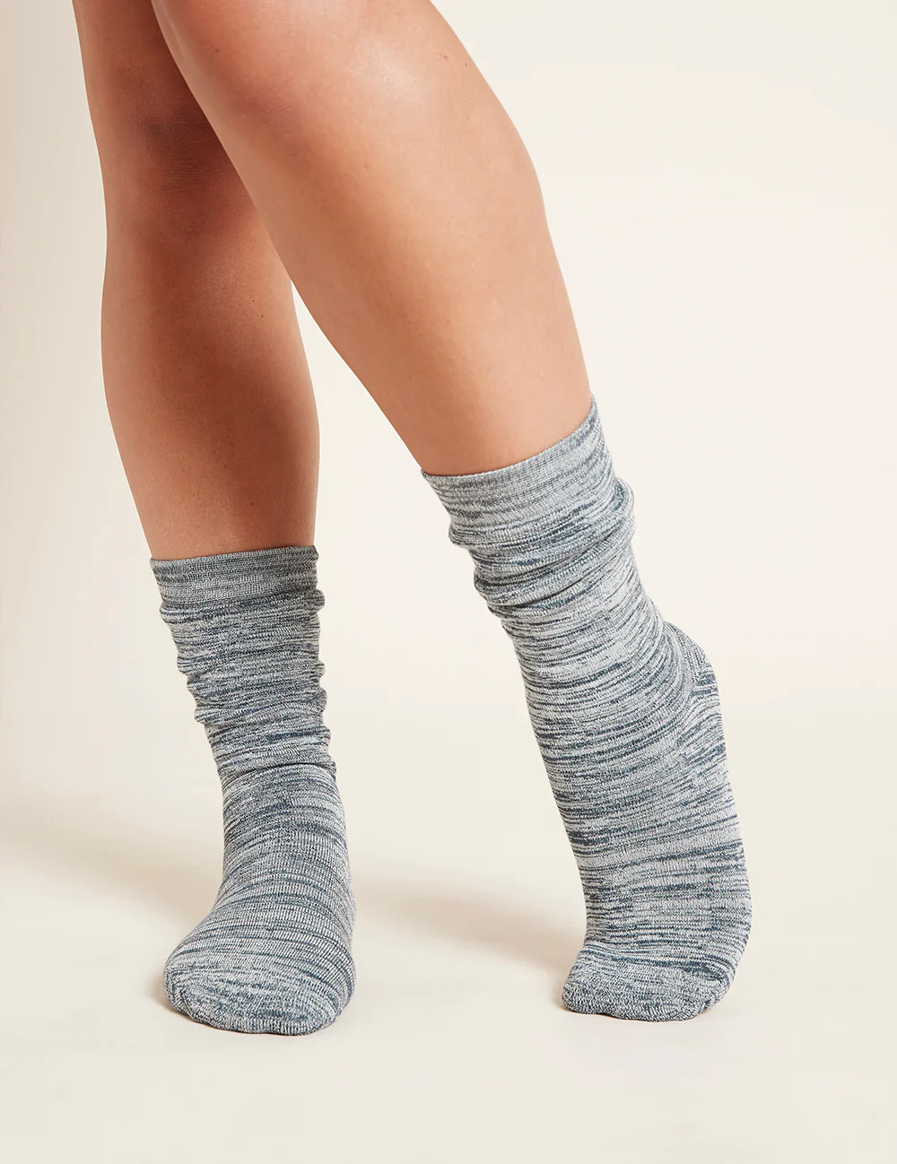 Gray marled socks worn by a person on a beige background