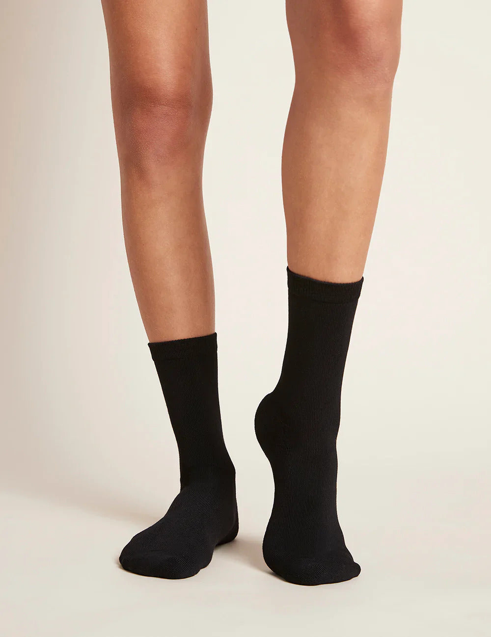 Black socks worn on a neutral background