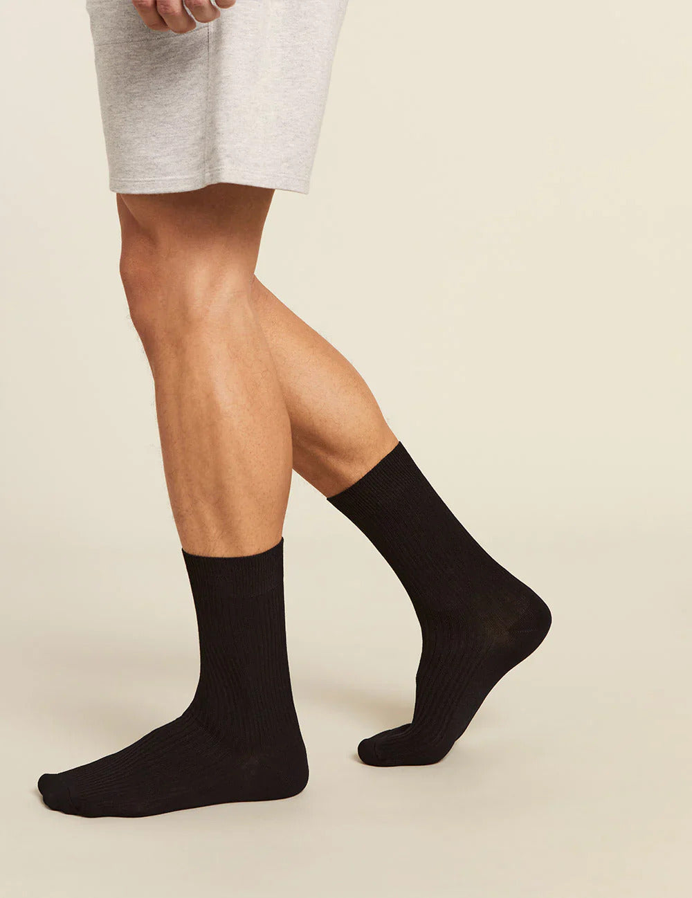 Person wearing black socks on a beige background