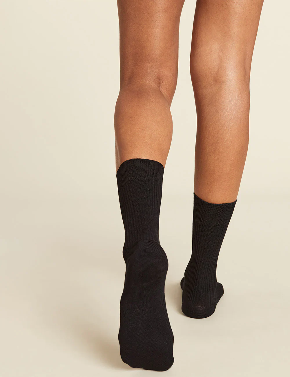 Black socks worn by a person on a beige background