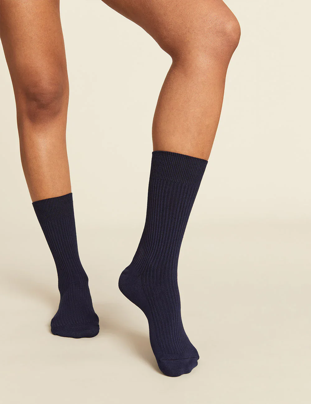 Navy blue socks worn by a person on a beige background