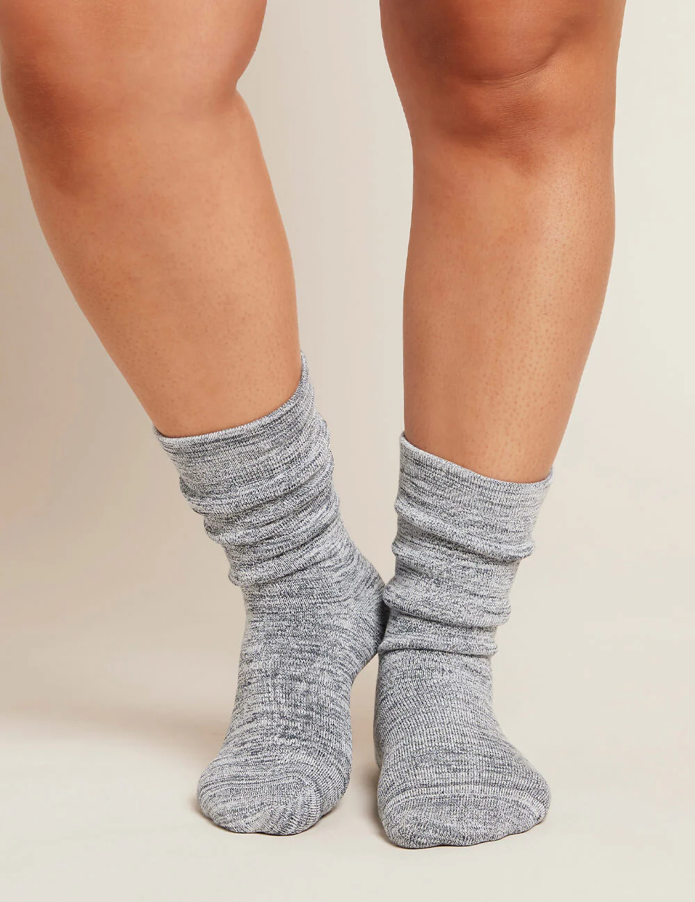 Gray socks worn by a person on a neutral background